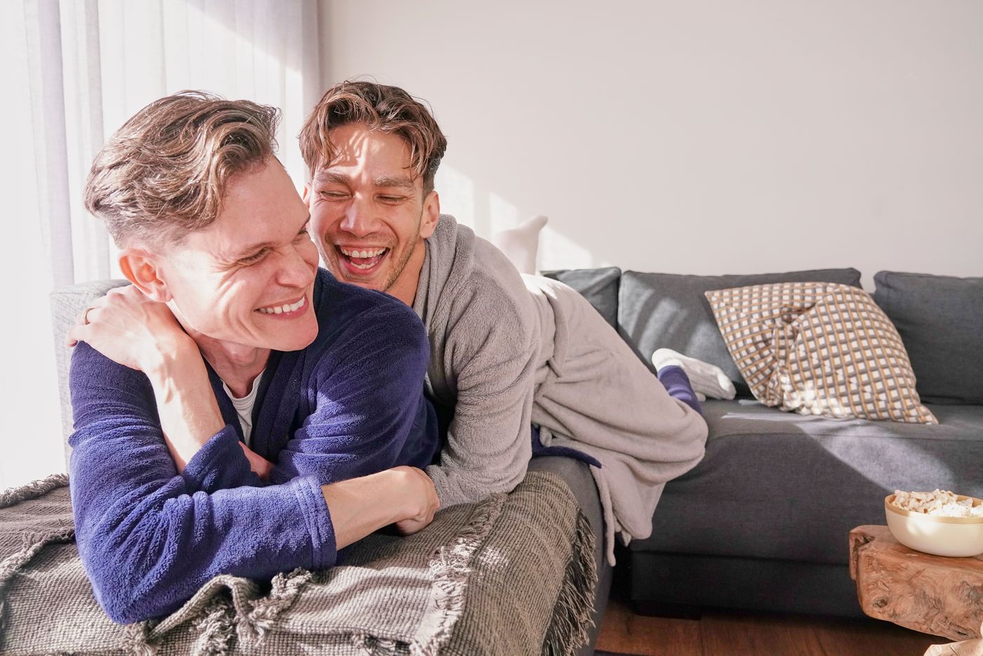 Two Gaydar members laughing together on the sofa